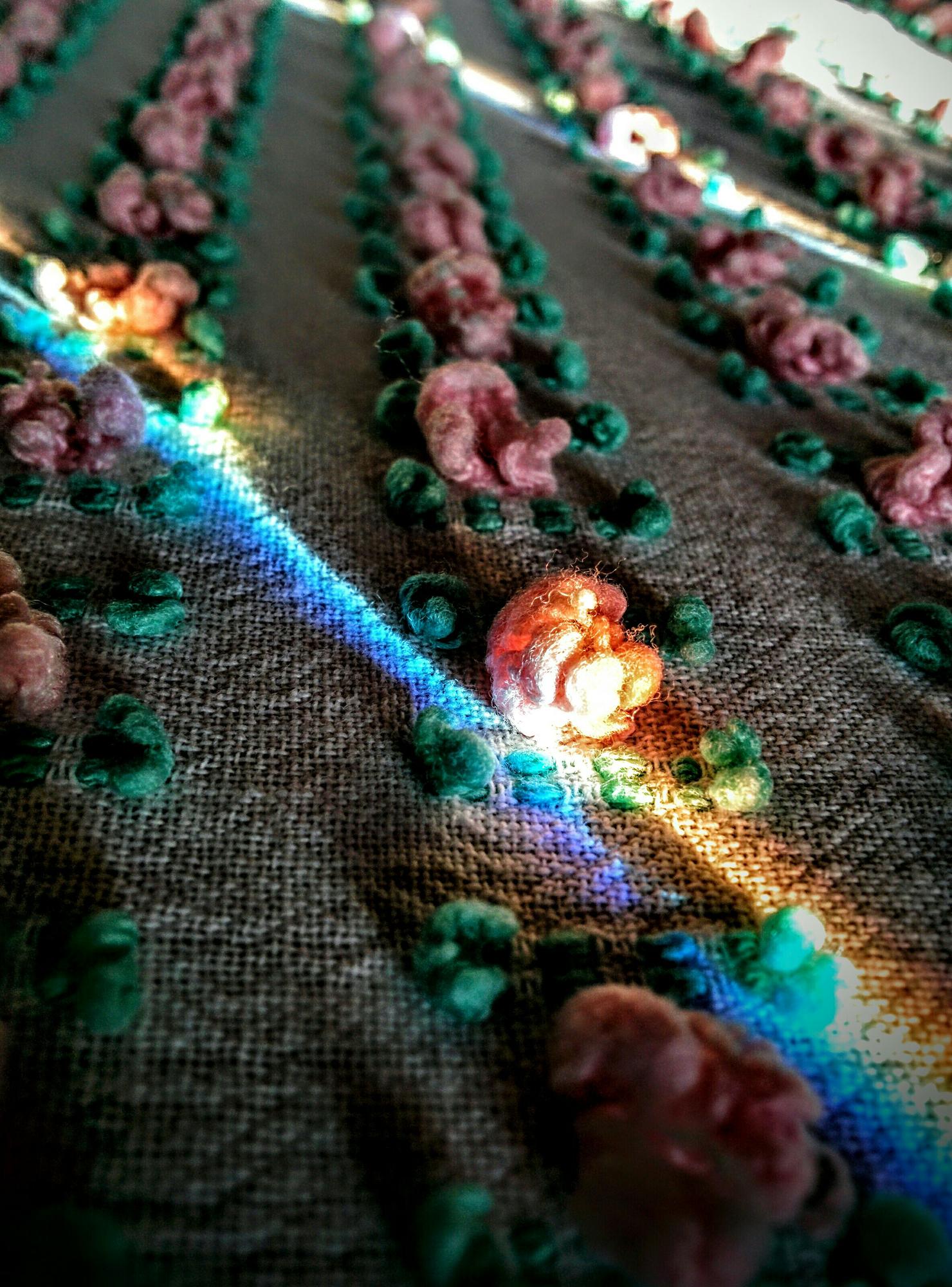 Close-up of embroidered circuit-like pattern on dark fabric